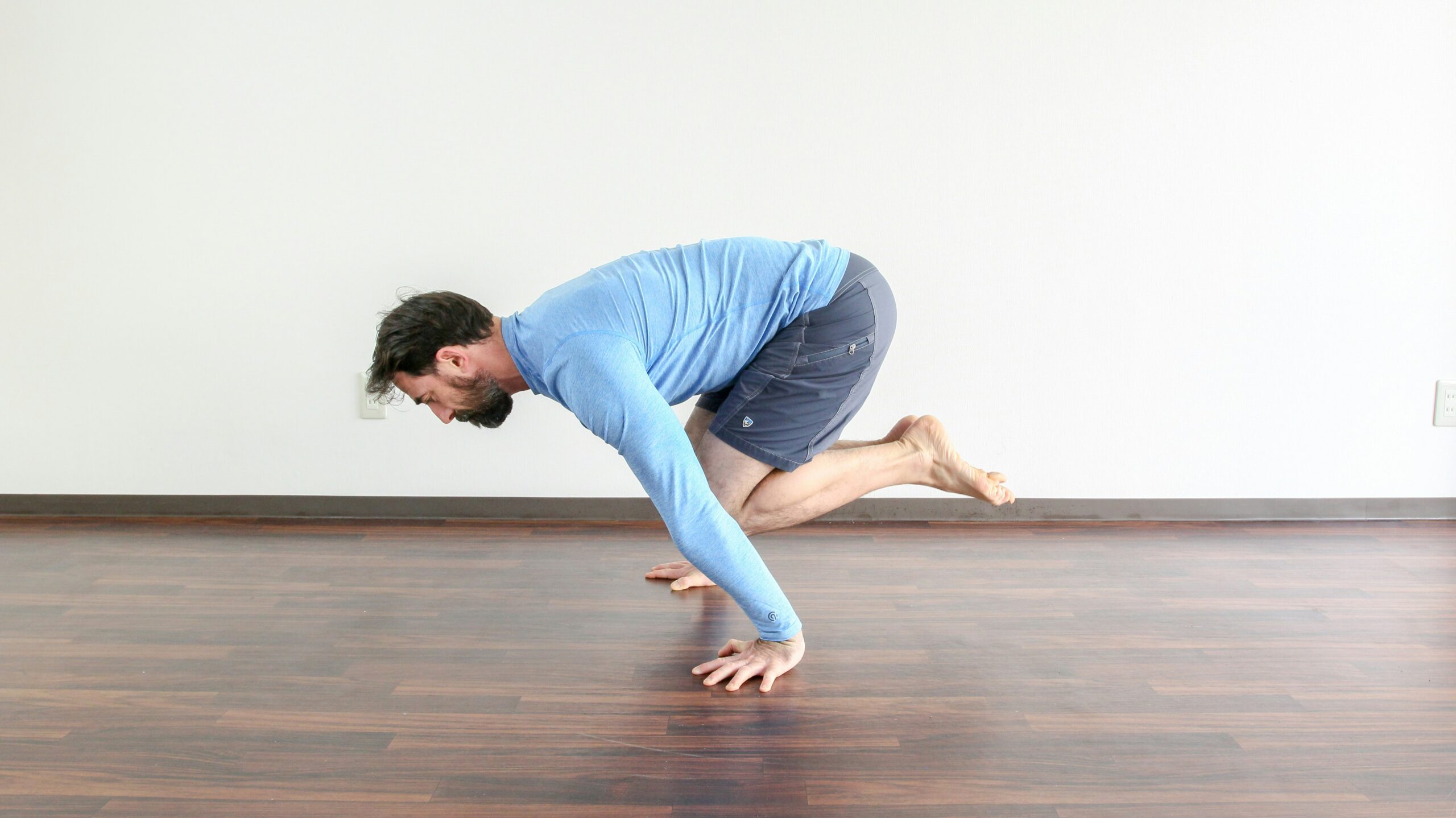 Man performing a bodyweight calisthenics movement in a training studio